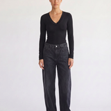 Woman wearing the Margaux black deep V henley top, front view