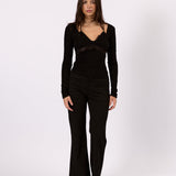 Woman wearing The Tailored Flare Pant in black, front view